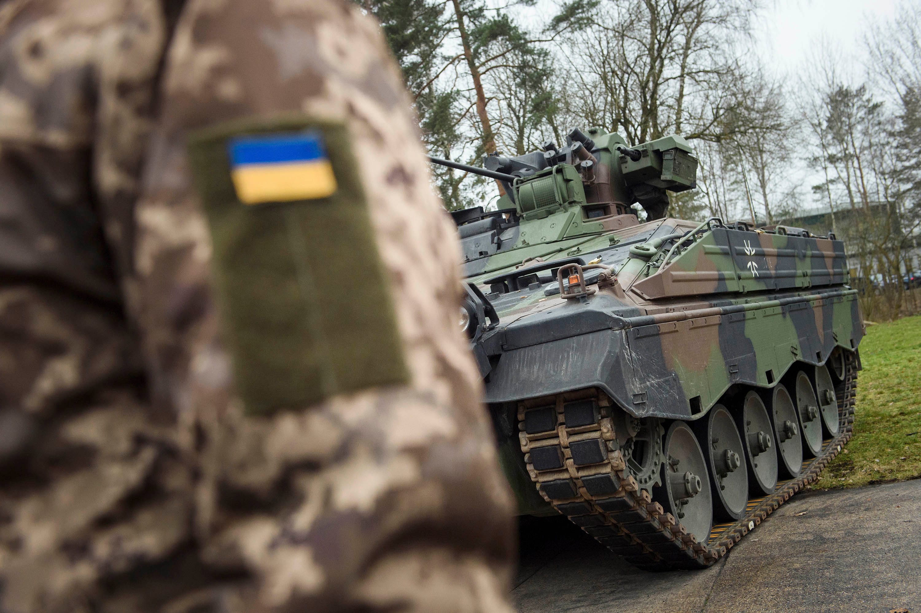 A Ukrainian soldier is standing in front of a Marder infantry fighting vehicle at the German forces Bundeswehr training area in Munster, Germany